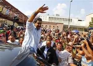 Acting Venezuelan President Maduro waves to supporters as he leaves after voting for the successor to the late President Chavez, in Caracas